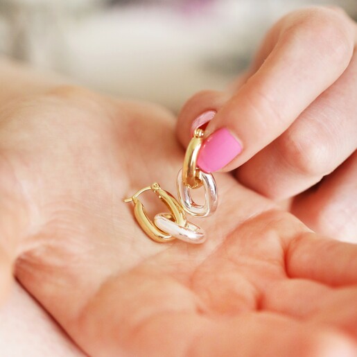 Mixed Metal Oval Link Huggie Hoop Earrings in Gold in palm of model's hand 