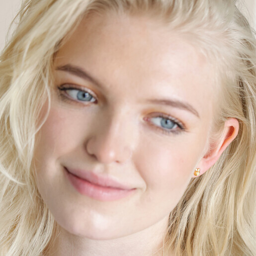 Model looking to side wearing Orange Opal Bee Stud Earrings in Gold