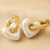 Pearl Resin Heart Huggie Hoop Earrings in Gold on Beige Coloured Fabric