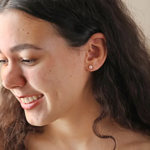 Model Smiling Looking to Side Wearing Pink Opal Flower Stud Earrings in Silver