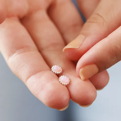 Model Holding Pink Opal Flower Stud Earrings in Silver in Between Fingers
