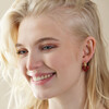 Model Smiling Wearing Red Resin Heart Huggie Hoop Earrings in Gold