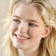 Model Smiling Wearing Rose Quartz Heart Stud Earrings in Gold