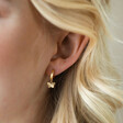 Close Up of Textured Butterfly Huggie Hoop Earrings in Gold on Model
