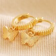 Textured Butterfly Huggie Hoop Earrings in Gold on Beige Coloured Fabric