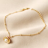 Pearl and Enamel Toadstool Charm Bracelet in Gold on Neutral coloured fabric