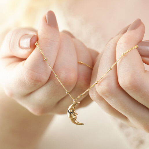 Model Holding Sleeping Moon Pendant Necklace in Gold Between Two Hands