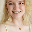 Blonde model wearing Smiley Sushi Pendant Necklace in Gold with pale strap top