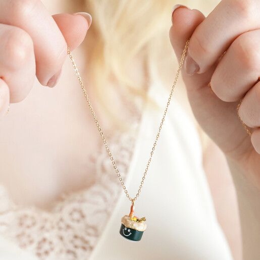 Model holding up the colourful Smiley Sushi Pendant Necklace in Gold