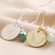 Personalised Birth Flower and Bail Birthstone Charm Necklaces on Beige Fabric