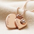 Close Up of Rose Gold Pendant on Personalised Double Heart and Birthstone Charm Necklace on Beige Fabric