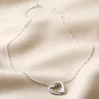 Personalised Sterling Silver Interlocking Hearts Necklace on Beige Fabric