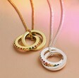 Rainbow Pride Eternity Pendant Necklaces on pink surface with rainbow lighting