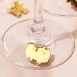 Close Up of Gold Pomeranian Charm from Set of 6 Dog Wine Glass Charms on Base of Wine Glasses