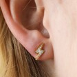 Close Up of Model Wearing Crystal Lightning Bolt Stud Earrings in Gold