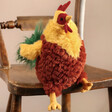 Jellycat Cluny Cockerel Soft Toy on Wooden Chair