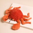 Jellycat Crispin Crab Small Soft Toy Laid on Neutral Coloured Background