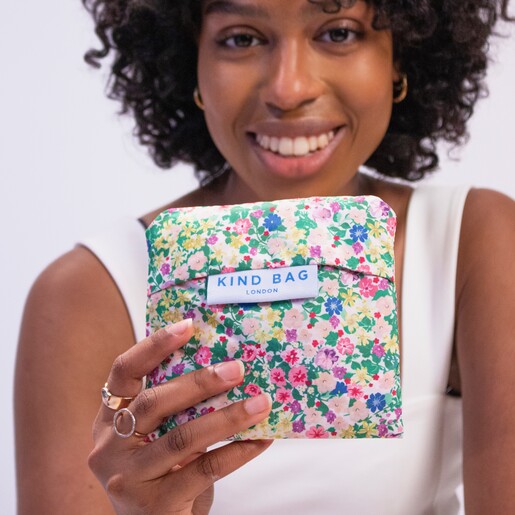 Model Holding Bag Pouch Model holding the Kind Bag Meadow Flowers Reusable Shopping Bag in its attached pouch
