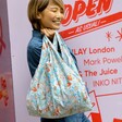 Model using the blue and orange Kind Bag Golden Lily Reusable Shopping Bag