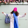 Model in blue scarf and pink hat wearing Kind Bag William Morris Strawberry Thief Reusable Shopping Bag