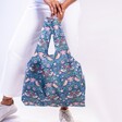 Model holding Kind Bag William Morris Strawberry Thief Reusable Shopping Bag by feet