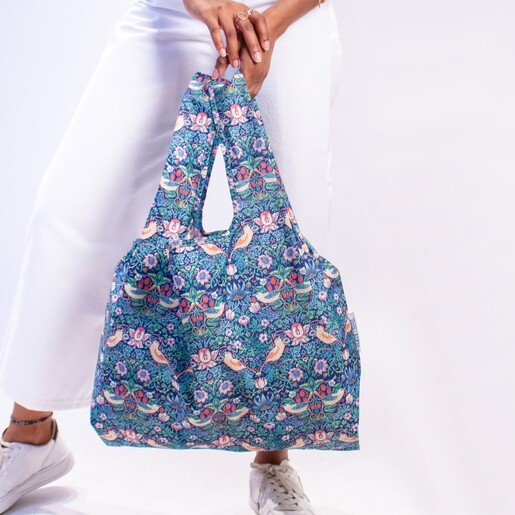 Model holding Kind Bag William Morris Strawberry Thief Reusable Shopping Bag by feet