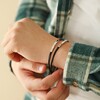 model wearing Men's Double Wrap Thin Leather Bracelet in Brown holding wrist