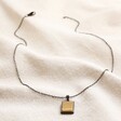 Men's Stainless Steel Tiger's Eye Pendant Necklace  with full chain showing on beige fabric