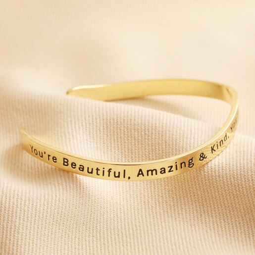 First Side of Adjustable All Things Lovely Meaningful Word Wave Bangle in Gold on neutral fabric