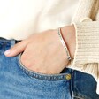 Adjustable 'All Things Lovely' Meaningful Word Wave Bangle in Silver on model with hand in pocket