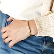 Adjustable 'Favourite Person' Meaningful Word Wave Bangle in Gold on model with hand in belt loop