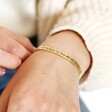Adjustable 'Favourite Person' Meaningful Word Wave Bangle in Gold on model holding band