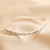 Side view of the Adjustable Favourite Person Meaningful Word Wave Bangle in Silver on beige fabric