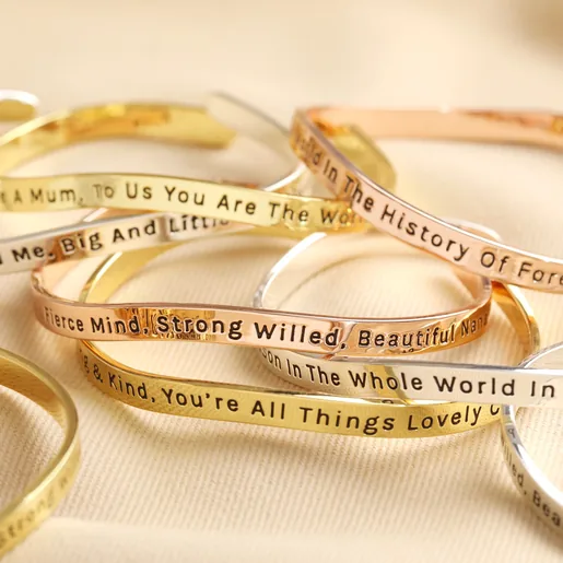 Adjustable 'All Things Lovely' Meaningful Word Wave Bangle in Silver with other meaningful word bangles stacked on neutral fabric