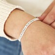 Adjustable 'Mum' Meaningful Word Wave Bangle in Silver on model holding band