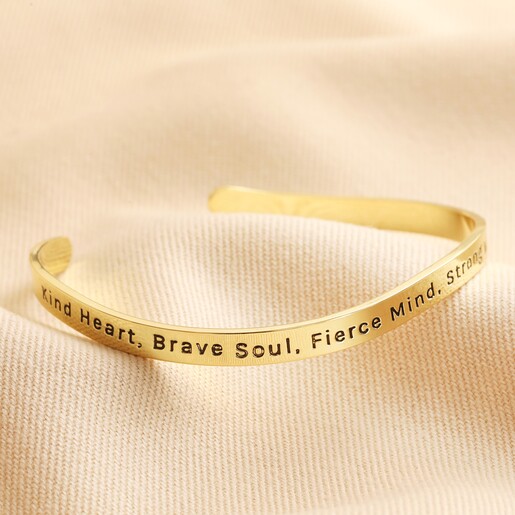 Adjustable Nana Meaningful Word Wave Bangle in Gold First Side of Adjustable Nana Meaningful Word Wave Bangle in Gold on Beige Fabric