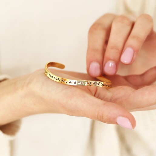Model Holding Bangle Model holding Adjustable 'Sisters' Meaningful Word Wave Bangle in Gold in palm of hand