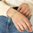 Adjustable 'Sisters' Meaningful Word Wave Bangle in Gold on model