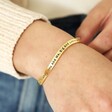 Adjustable 'Sisters' Meaningful Word Wave Bangle in Gold on model holding band
