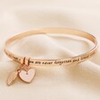 'Never Forgotten' Meaningful Word Bangle in Rose Gold on Neutral Fabric