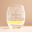 Norwich Engraved Gin Tumbler with Lemon slice and water inside on beige background