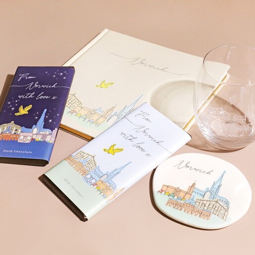 Norwich Organic Shape Coaster with Norwich Notebook, Chocolate and Glass on Beige Surface