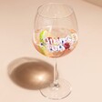 Personalised Floral Balloon Gin Glass with liquid inside on neutral coloured background