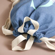 Close up of opening on Personalised Initial Name BagBase Denim Drawstring Bag with neutral background