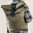 Model Wearing Personalised Message BagBase Roll Top Backpack in Military Green