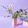 Sass & Belle Pink Gingham Vase in lifestyle shot with purple background