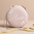 Personalised Flower Mini Round Travel Jewellery Case in Lilac Pink Standing on Neutral Surface with Gold Jewellery Scattered Around