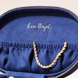 Personalised Sun and Moon Embroidered Oval Jewellery Case in Navy Open with Jewellery Inside on a Natural Coloured Backdrop