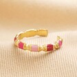 Adjustable Pink Enamel Twist Ring in Gold on Beige Fabric