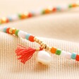 Close up of Colourful Pearl and Tassel Beaded Anklet in Gold on neutral fabric